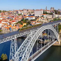 Most zwodzony w Porto z żółtym tramwajem, widok na miasto i rzekę. Szukasz informacji o wino porto cena?