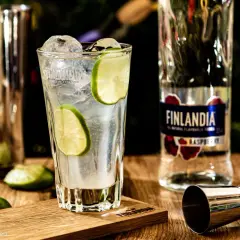 Orzeźwiający drink z lodem i limonką, obok butelka Finlandia Raspberry. Idealny na letnie wieczory.