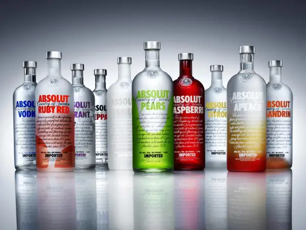 Rząd butelek wódki Absolut: od klasycznej po owocowe smaki, każdy symbolizuje czysty **absolut** smaku i szwedzkiej tradycji.