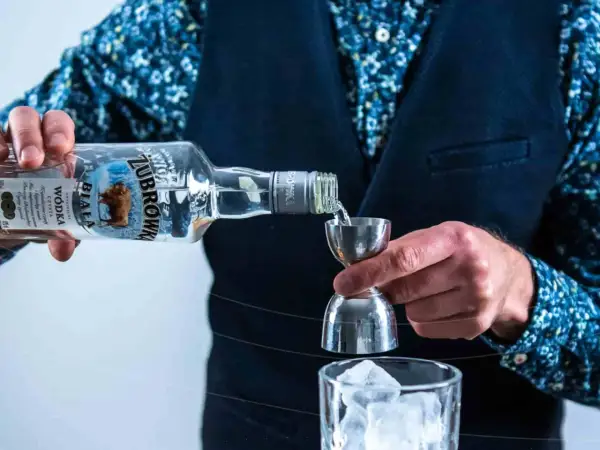 Barman nalewa Żubrówkę do jiggera. To dobra wódka na drinki.